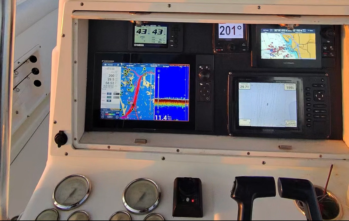 Helm dash with Furuno chartplotter, Garmin display and Yamaha engine gauges