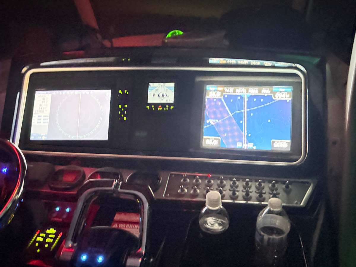 Illuminated helm with radar, chartplotter and switching panel during a night run